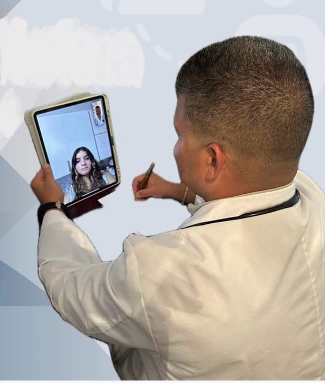 Man in beige shirt holding a foldable tablet device showing a video call with a woman on screen